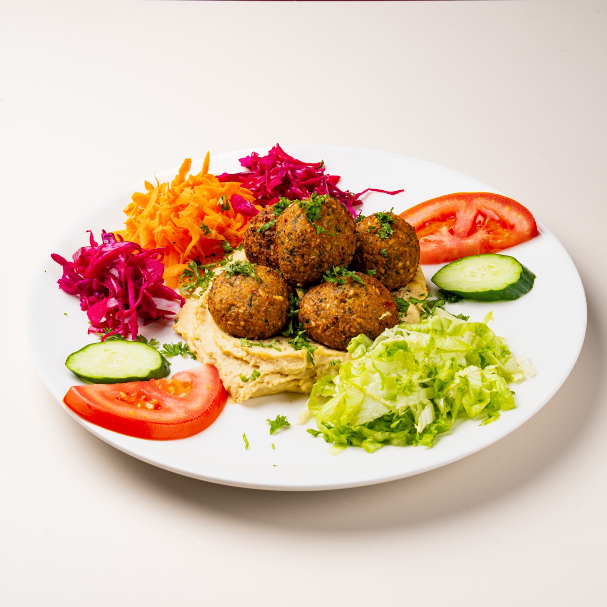 Crispy falafel pieces on a bed of hummus